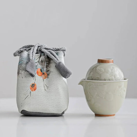 Vintage ceramic travel tea set with teapot, cups, and linen carry bag.